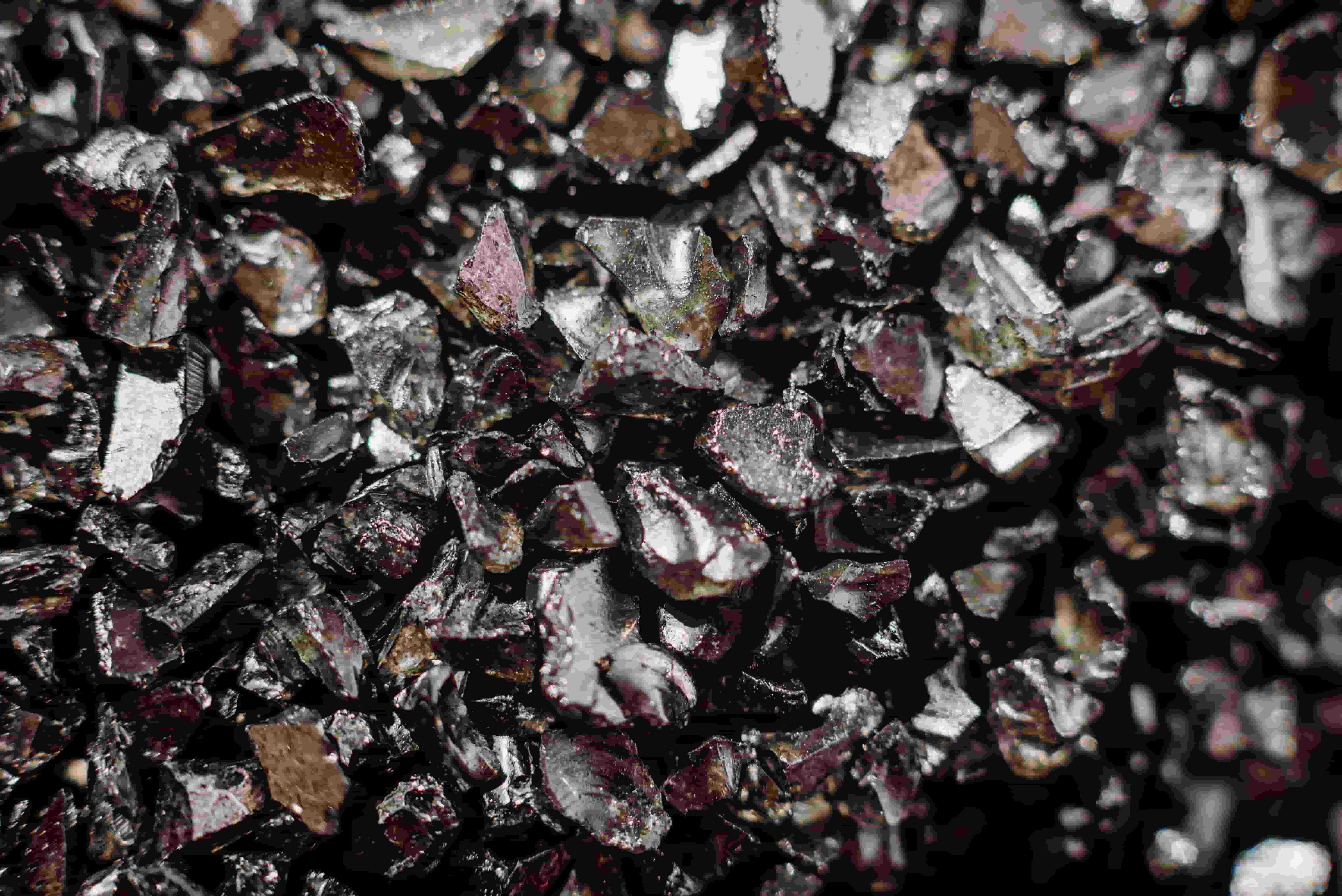 A collection of black rocks, representing the essential resources for the growing demand for rare-earth elements.