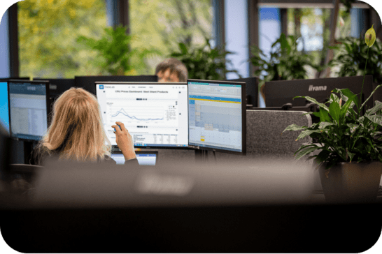 Woman in front of a desktop computer showing charts