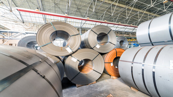 Aluminium rolled products stacked on top of each other in a warehouse.